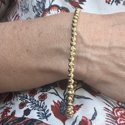 10K Solid Gold  diamond cut beaded bracelet on a hand 
