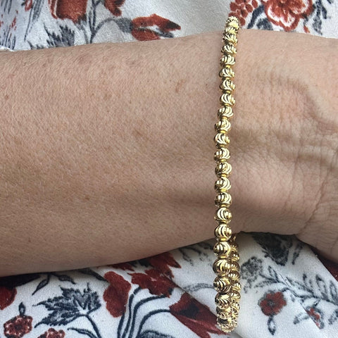 10K Solid Gold  diamond cut beaded bracelet on a model 